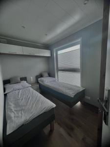 a room with two beds and a window in it at Apartament Holiday in Dąbki