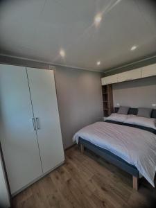 a bedroom with a bed and a large cabinet at Apartament Holiday in Dąbki