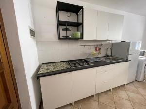 eine Küche mit weißen Schränken und einem Herd mit Backofen in der Unterkunft Casa Corbatto Family Apartment in Grado in Grado