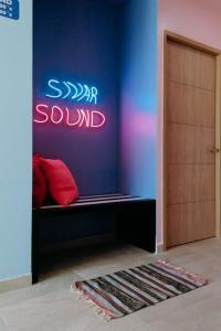 a room with a bench with a sign on the wall at ¡Sivar Sound! Music Design! in San Salvador