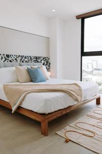 a bedroom with a large bed with a large window at ¡Sivar Sound! Music Design! in San Salvador