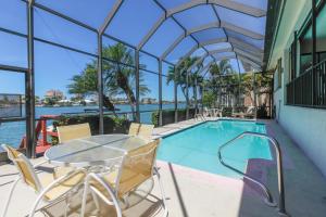 a swimming pool with a table and chairs in a building at The Marco Mariner in Marco Island