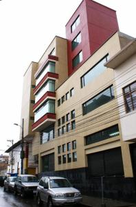 un edificio con coches estacionados frente a él en HOTEL FLOR DE LOS ANDES en Tulcán