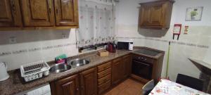 a small kitchen with wooden cabinets and a sink at Casa Viela in Viseu +12 photos