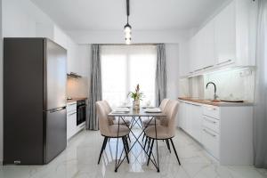 a kitchen with a table with chairs and a window at Amersa Luxury Apartment in Néa Alikarnassós