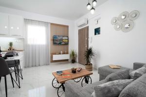 a living room with a couch and a table at Amersa Luxury Apartment in Néa Alikarnassós