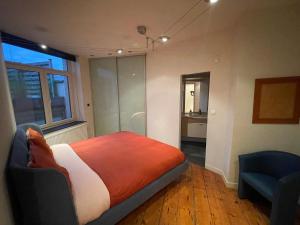 um quarto com uma cama, uma cadeira e uma janela em Les Charmes d'Ostende em Oostende