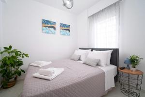 Un dormitorio blanco con una cama con toallas. en Amersa Luxury Apartment, en Heraclión