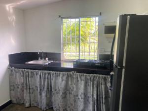 eine Küche mit einer Spüle, einem Kühlschrank und einem Fenster in der Unterkunft La lila in San Bernardo del Viento