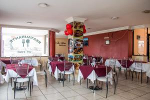un restaurante con paredes rojas, mesas y sillas blancas en HOTEL FLOR DE LOS ANDES en Tulcán