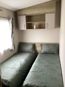 mały pokój z 2 łóżkami i oknem w obiekcie Staycation For You (Kent) w mieście Leysdown-on-Sea