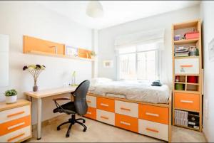 um quarto com uma secretária e uma cama com armários laranja em 3 La Casa De Marilo em Tomares