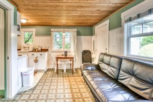 a living room with a leather couch and a table at Hidden Villa Cottages #1, #2, and #3 in Cannon Beach
