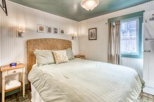 a bedroom with a large bed and a window at Hidden Villa Cottages #1, #2, and #3 in Cannon Beach