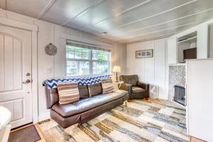 a living room with a leather couch and a chair at Hidden Villa Cottages #1, #2, and #3 in Cannon Beach
