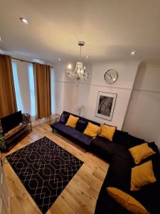 a living room with a couch and a clock on the wall at B&T Pleasure Homes - Southend in Southend-on-Sea