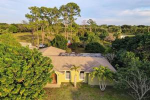 an overhead view of a yellow house with trees at Ananda Farmhouse and Retreat. in Lake Worth