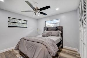 a bedroom with a bed with a ceiling fan at Ananda Farmhouse and Retreat. in Lake Worth