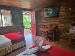 dos cisnes sentados en una habitación con una cama y una mesa en Cabañas Colibrí, en Bacalar 125 fotos más