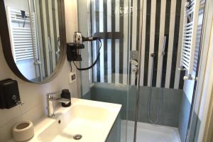 a bathroom with a sink and a shower with a mirror at Appartamento Sofia - CISE 18741 in Rome