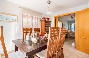 uma sala de jantar com uma mesa de madeira e cadeiras em 3 La Casa De Marilo em Tomares