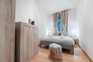 a bedroom with a bed and a wooden cabinet at FUNICOLARE 23 - Hystoric Apartment Immerso nel Cuore di Città Alta in Bergamo