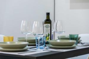 - une table avec des assiettes, des verres et une bouteille de vin dans l'établissement FUNICOLARE 23 - Hystoric Apartment Immerso nel Cuore di Città Alta, à Bergame