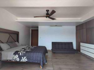 a bedroom with a bed and a ceiling fan at BRISAS GUITARRON in Acapulco