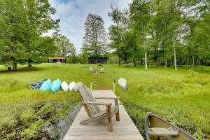 une terrasse en bois avec un banc et un bateau dans un champ dans l'établissement Lakefront Catskills Container Home Private Lake, à Swan Lake
