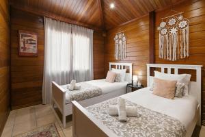 zwei Betten in einem Zimmer mit Holzwänden in der Unterkunft Casa da Poesia in Pedreiras + 26 Fotos