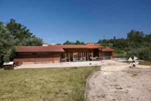 ein großes Holzhaus inmitten eines Feldes in der Unterkunft Casa da Poesia in Pedreiras