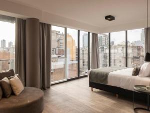 um quarto com uma cama e uma grande janela em Casa Joseph em Buenos Aires