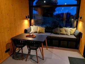 a living room with a couch and a table and a window at Tiny House 1 im schönen Allgäu mit großem Garten, Naturnah in Bad Wurzach