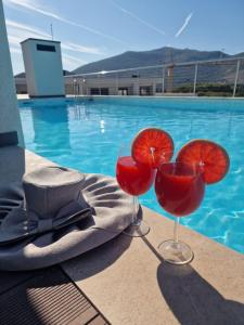 dois copos de vinho tinto ao lado de uma piscina em Kathisma Trebinje em Trebinje