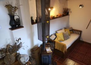 Habitación con sofá y almohadas amarillas. en Toca do Esquilo - Montesinho, en Montezinho