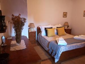 Toca do Esquilo - Montesinho في Montezinho: غرفة نوم بسرير وطاولة عليها مزهرية