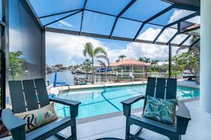 a pair of chairs sitting next to a swimming pool at Goldenrod House is Your Golden Ticket to Paradise! in Marco Island