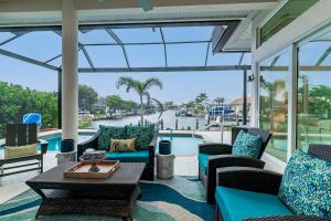 a conservatory with chairs and a table and a pool at The Goldenrod House I Ultimate Escape on Marco Island in Marco Island