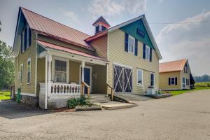 una casa amarilla con techo rojo en Vintage Adirondacks Apartment Close to Hiking, en Port Henry