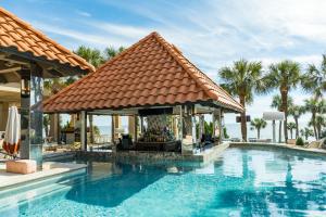 a pool with a gazebo next to a house at San Luis Ocean Oasis in Galveston