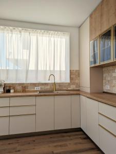 a kitchen with white cabinets and a window at La Bella Villa Mamaia in Mamaia Nord