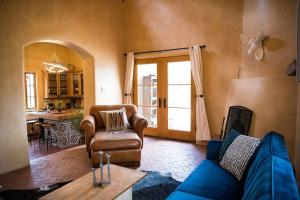 a living room with a blue couch and a table at Sun and Ski! Beautiful, Downtown, on 1.5 Acres! in Santa Fe