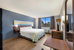 a hotel room with a bed and a television at HomeTowne Studios by Red Roof Painted Post in Painted Post +29 photos