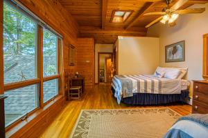 a bedroom with two beds and large windows at Lakeside Cottages on Toddy Pond in Orland