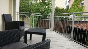 a porch with chairs and a table and a fence at Ländlicher Rückzugsort im Herzen von Mühlhausen in Mühlhausen