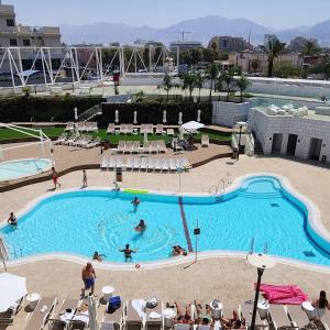 una grande piscina con persone di Sweet Sea Side Eilat - סוויט סי סייד, אילת a Eilat