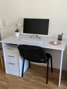 ein weißer Schreibtisch mit einem Computer darüber in der Unterkunft Wunderschöne, neue Wohnung mit großer Terrasse in Ebenthal