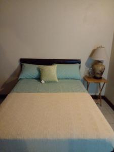 een slaapkamer met een bed en een nachtkastje met een lamp bij Upton Heights in Ocho Rios