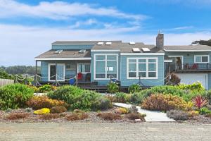 a blue house with a garden in front of it at Sea Dream and Sand Dollar Suite in Fort Bragg