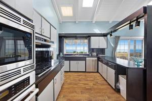 a large kitchen with white cabinets and black counter tops at Sea Dream and Sand Dollar Suite in Fort Bragg